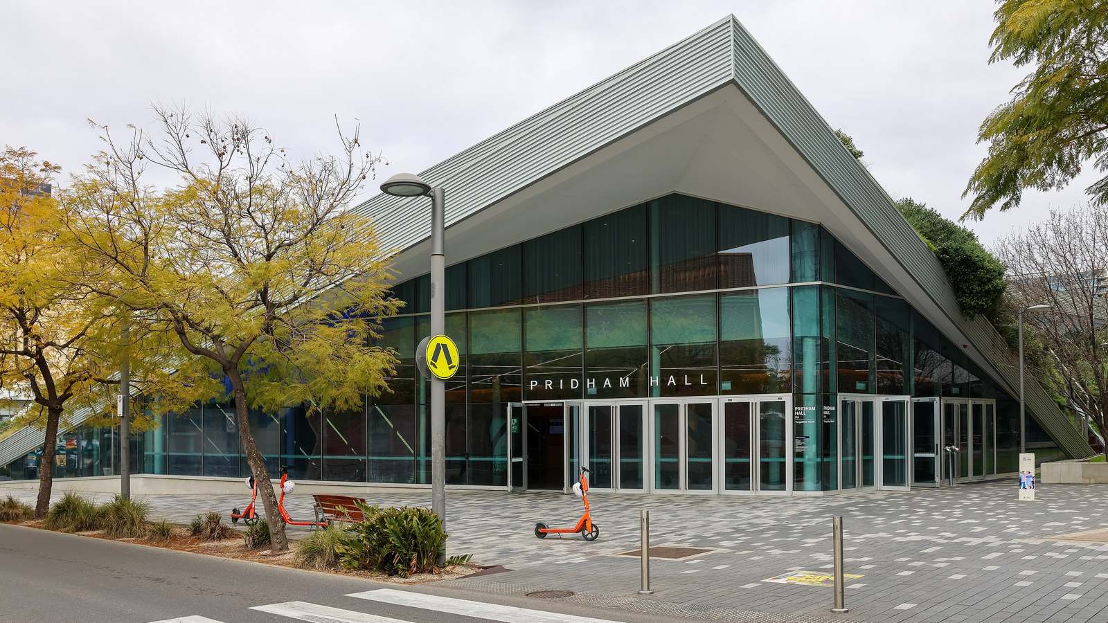 The angular glass front of Pridham Hall on Adelaide University's City West campus beside a pedestrian crossing