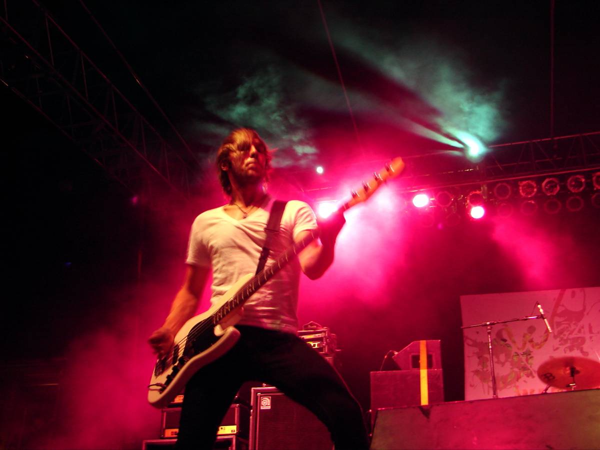Anberlin bassist Deon Rexroat playing under red and green stage light