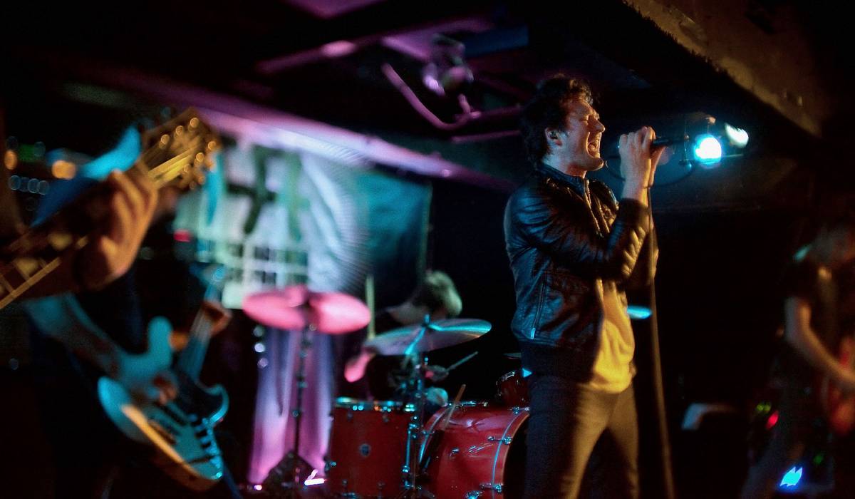 Anberlin playing a club stage lit in blue and teal