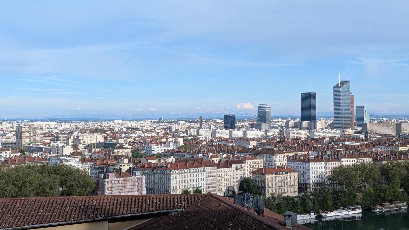 View over the rooftops of Lyon towards the towers of the Part Dieu business district and distant mountains