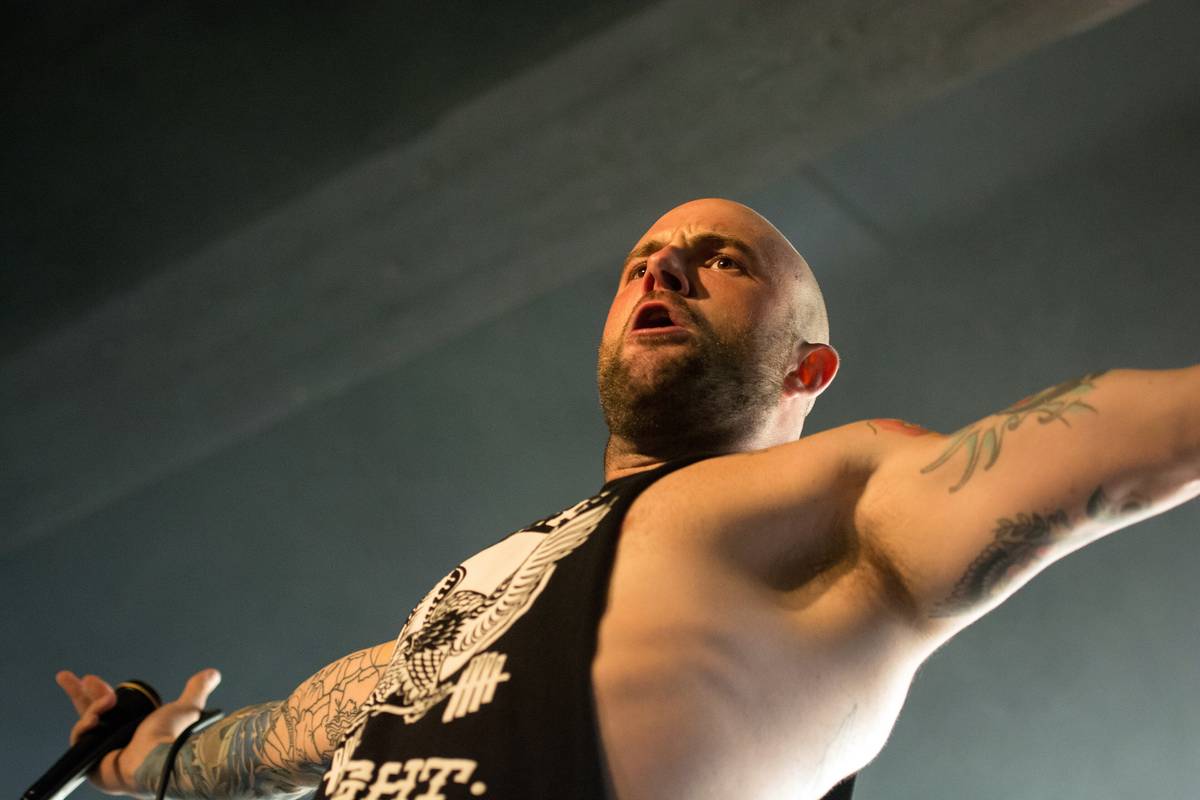August Burns Red singer Jake Luhrs on stage with arms outstretched