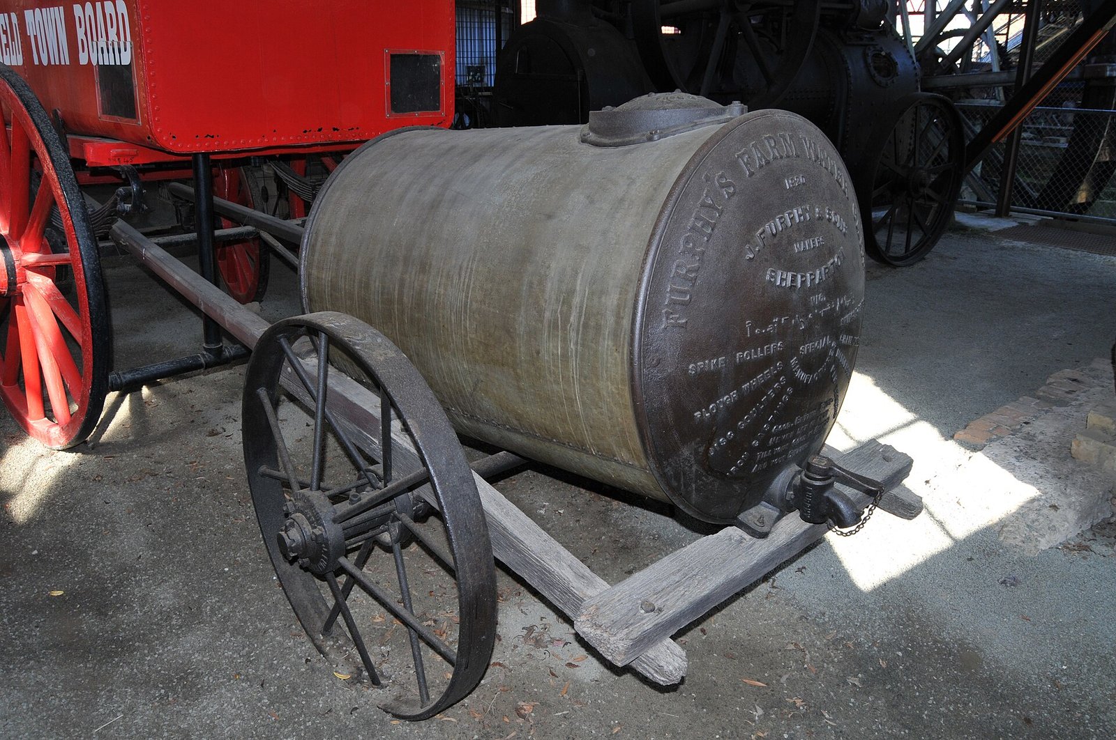 A restored cast-iron Furphy water cart on display in a museum