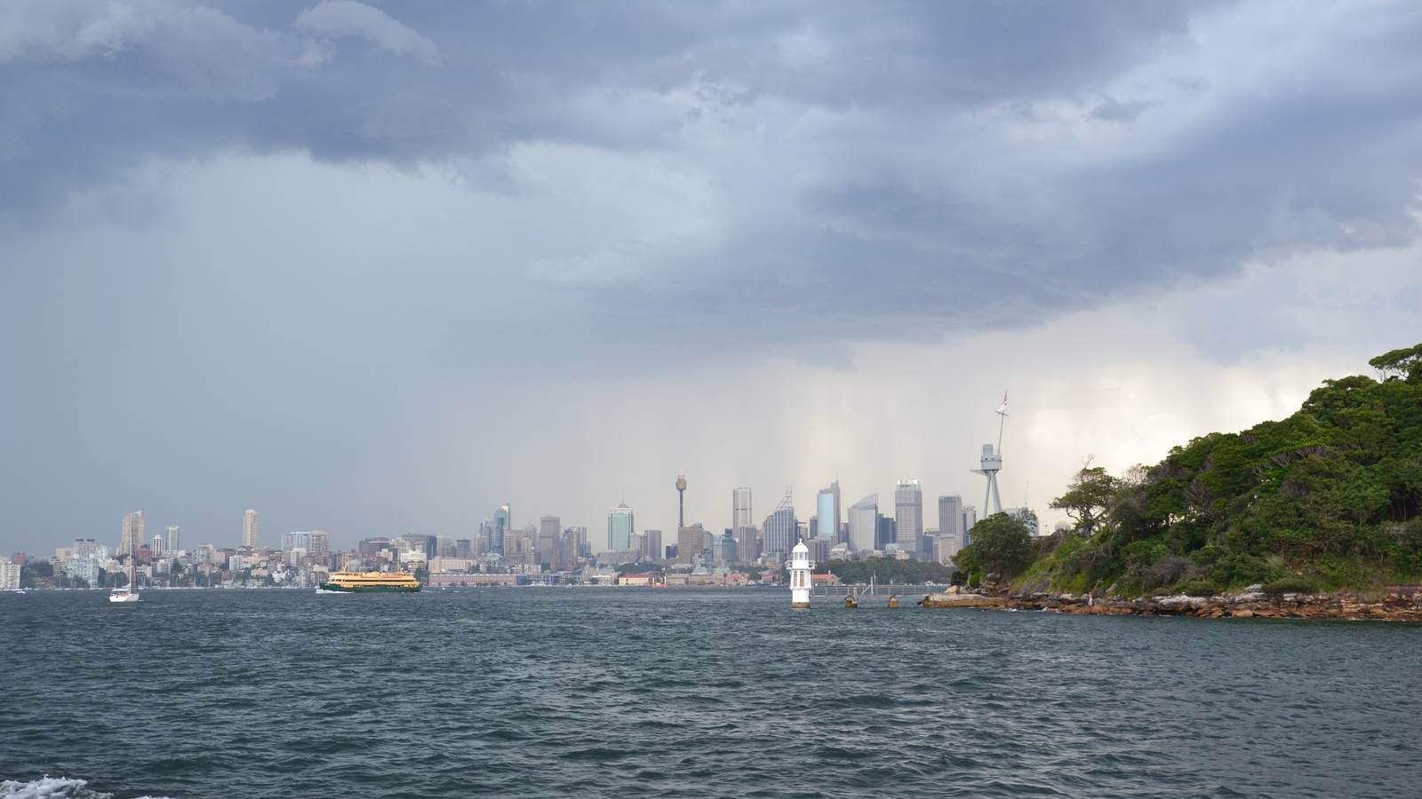 Dark storm clouds and rain over Sydney Harbour and the city skyline