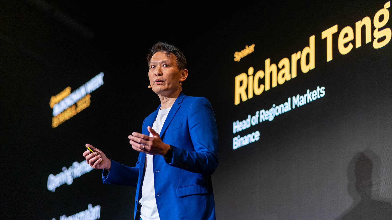 Binance co-chief executive Richard Teng in a blue jacket speaking on stage at Binance Blockchain Week in Istanbul