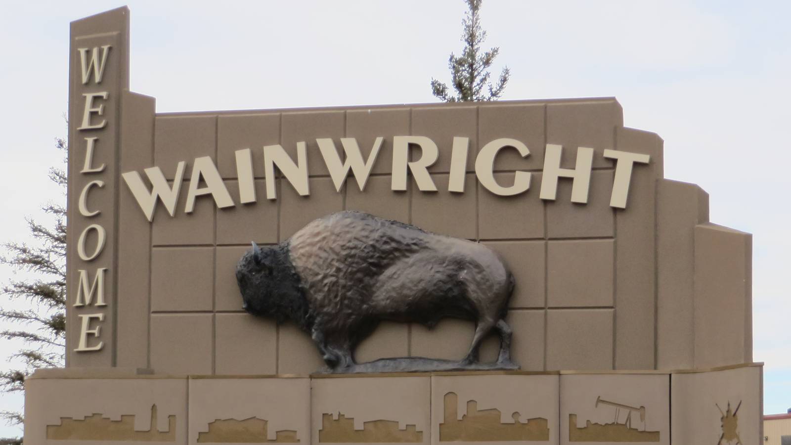 The Wainwright welcome sign in Alberta, with a bronze bison sculpture and the town name in raised letters