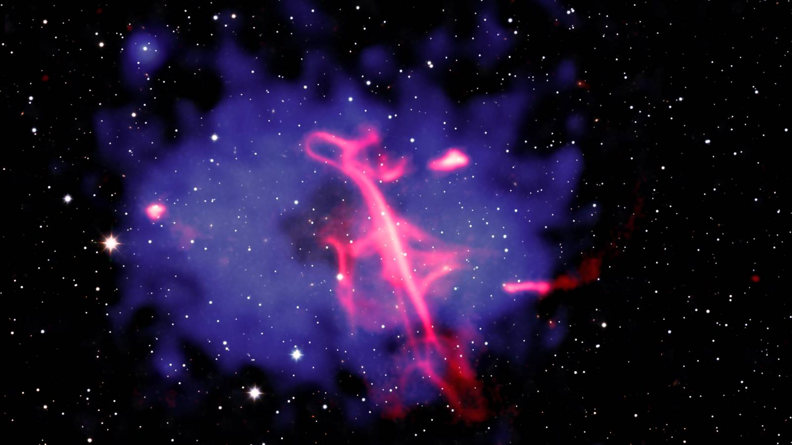 A pink twisting band of radio light threading through a blue haze of hot gas against a field of stars
