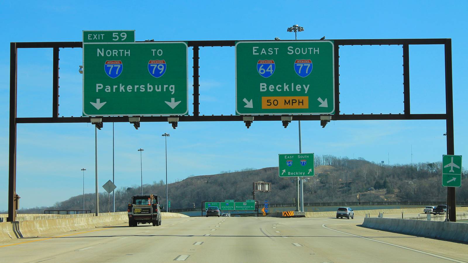 Overhead signs for the Interstate 64 and Interstate 77 split at Exit 59 on the elevated highway in Charleston, West Virginia