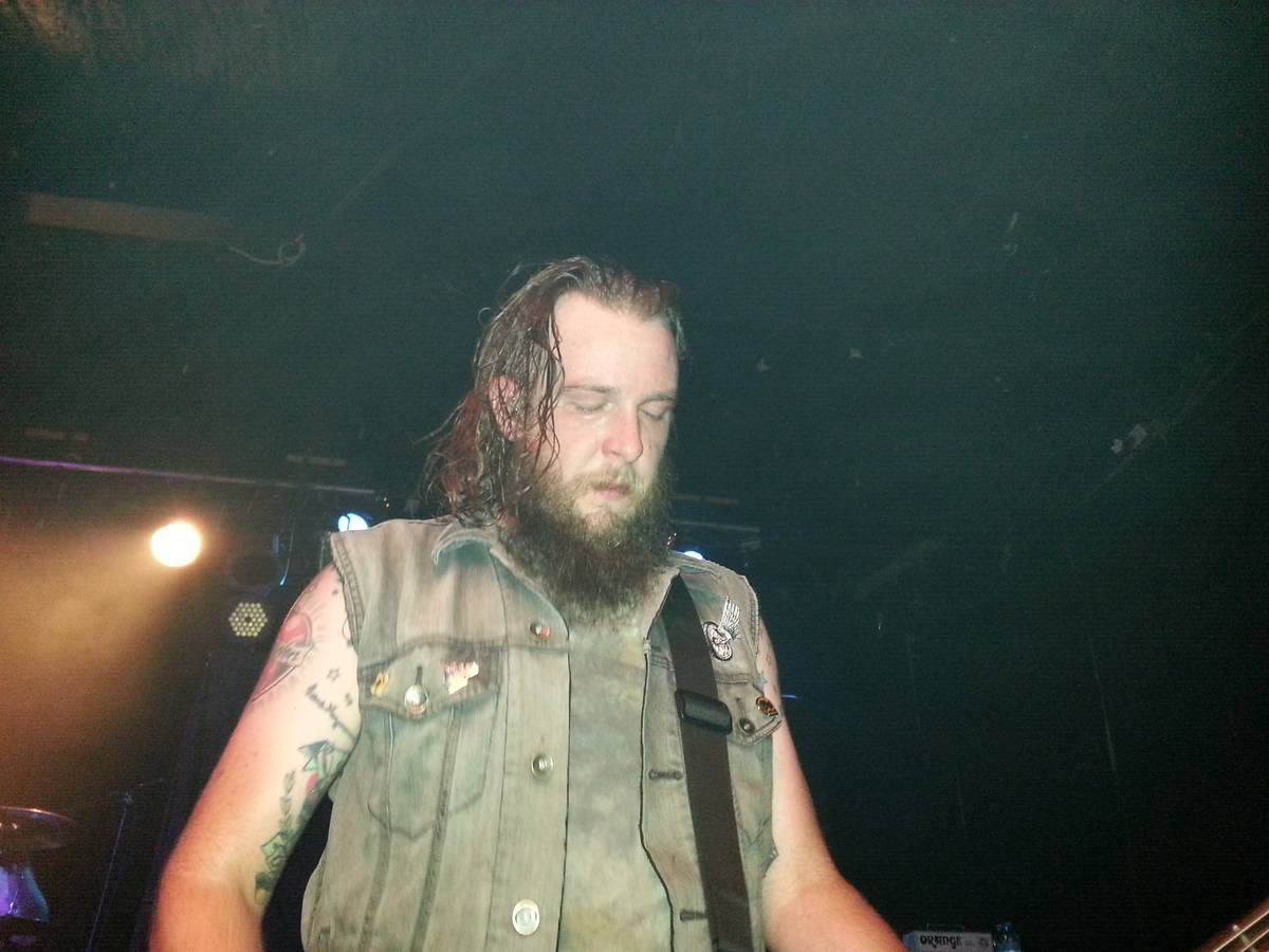 Demon Hunter bassist Jon Dunn on stage in a sleeveless vest
