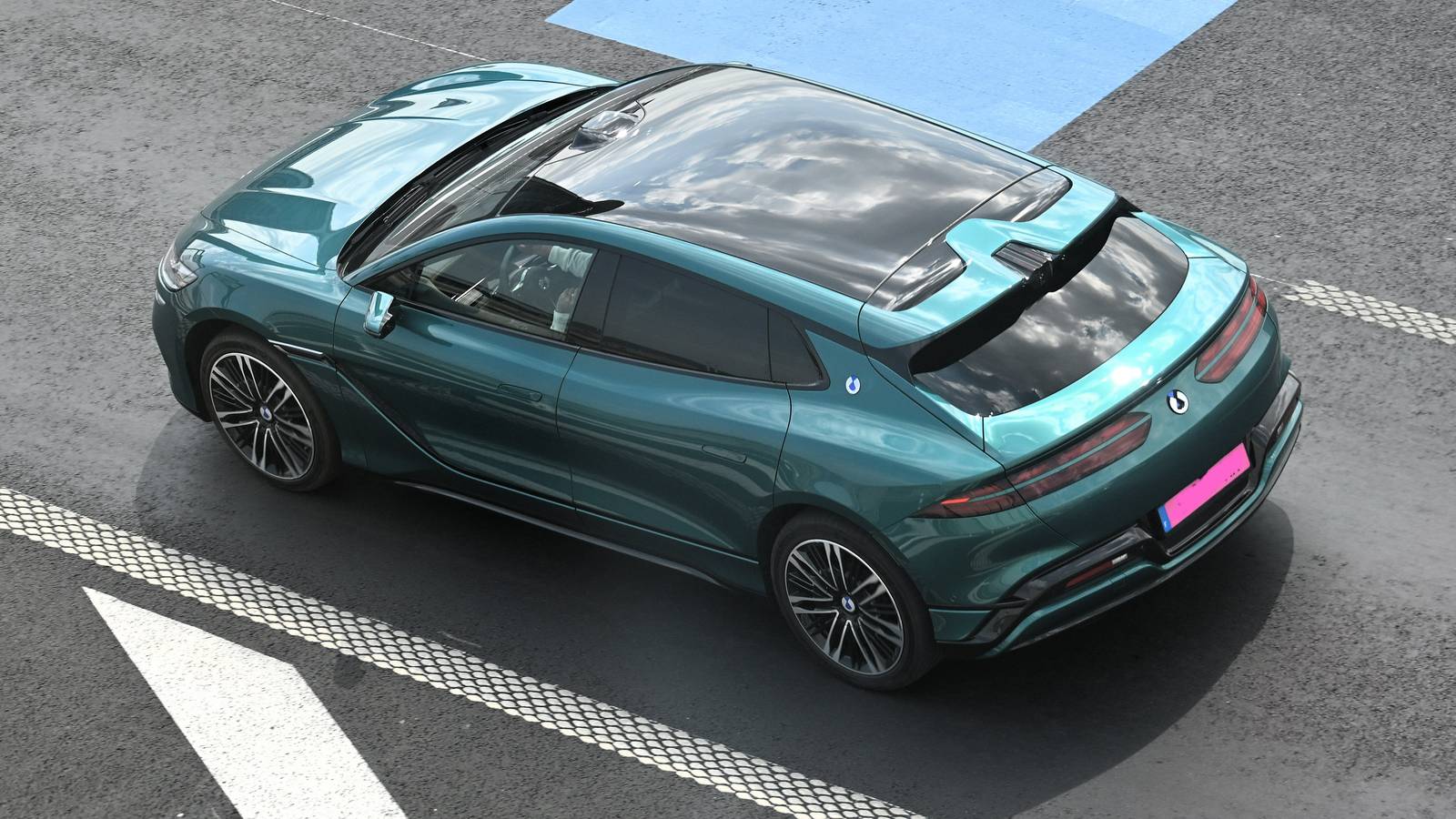 A teal Denza Z9 GT seen from above in a car park beside a blue parking bay