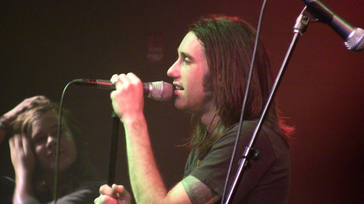 Disciple singer Kevin Young singing into a microphone on stage