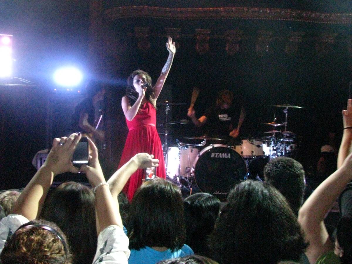 Flyleaf performing to a crowd with phones and hands raised
