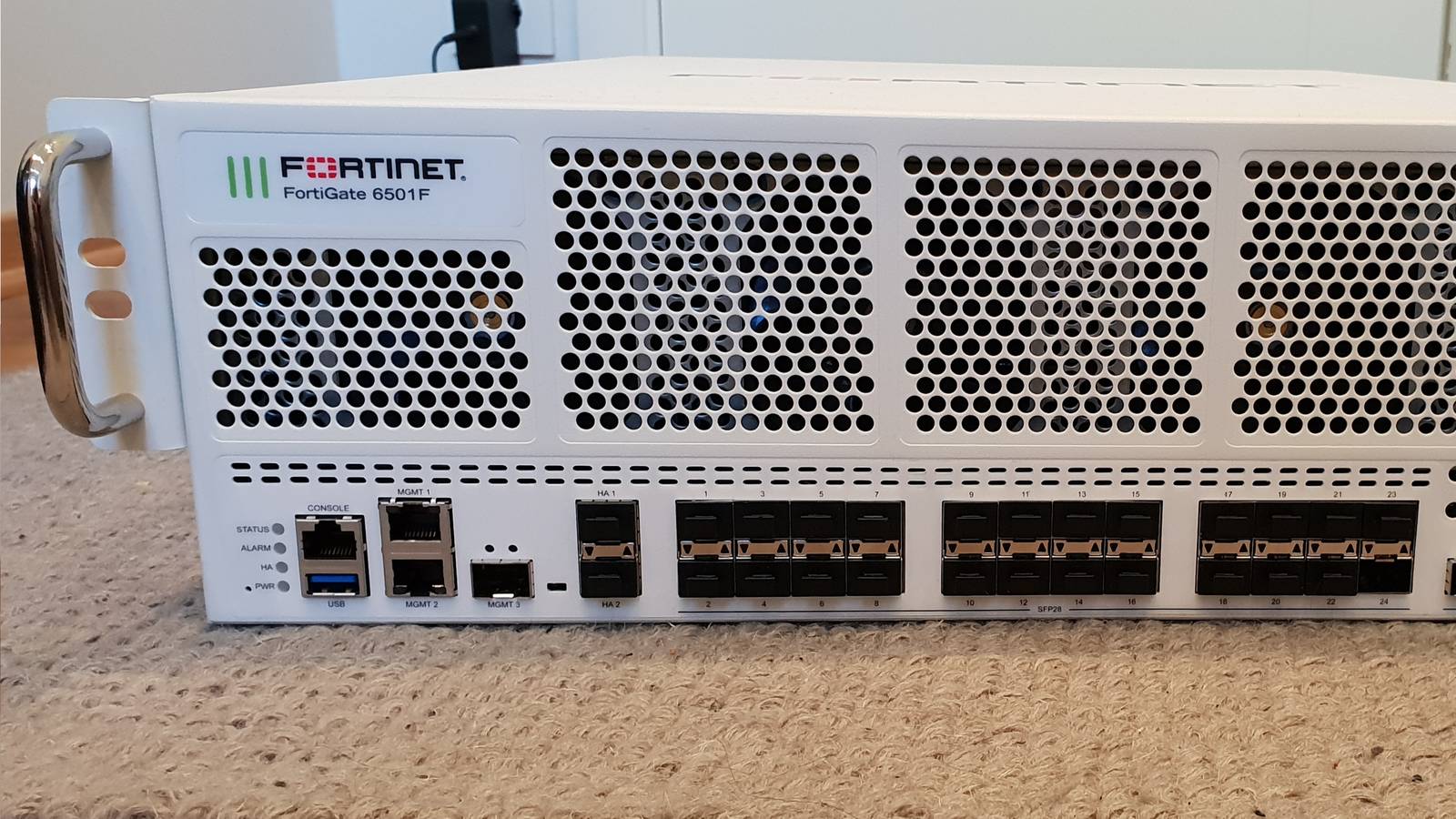 Front panel of a white Fortinet FortiGate 6501F rack mounted firewall appliance with its network ports
