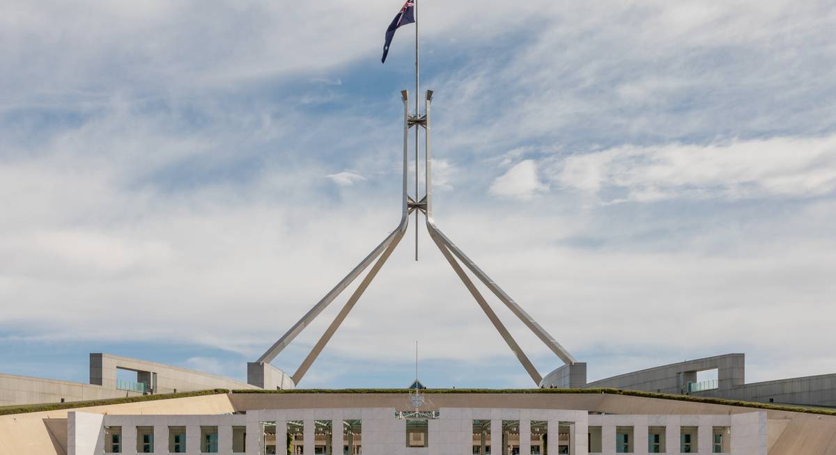 The flag mast above Parliament House, Canberra, under a partly cloudy sky