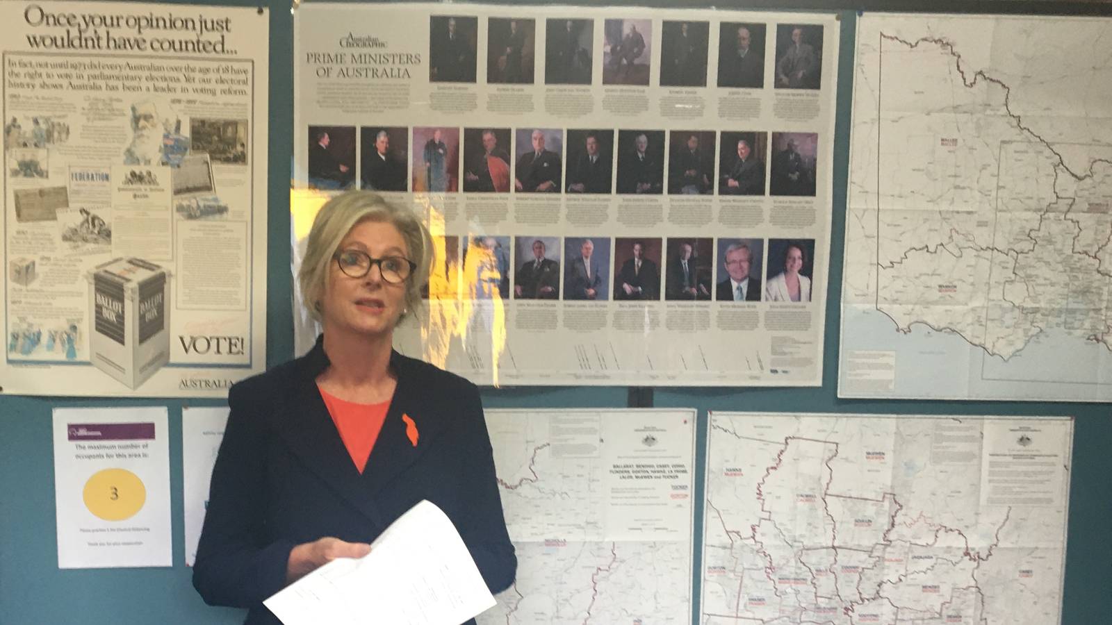 Independent MP Helen Haines reading from notes in front of electoral maps at the Indi results declaration