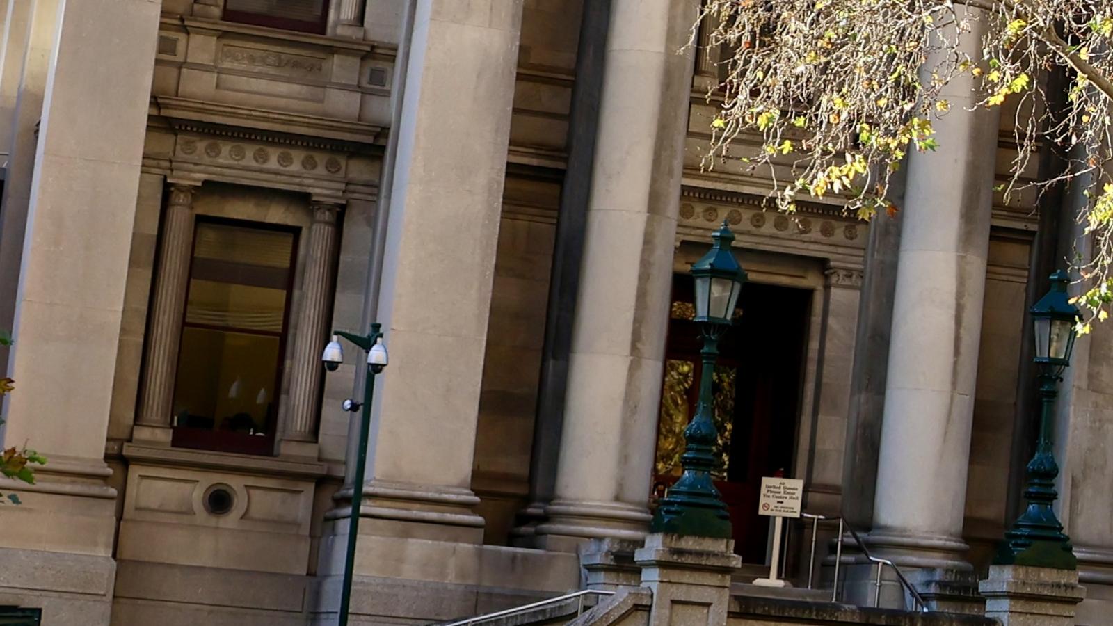 Sandstone columns, green lamps and the front entrance of Parliament House on North Terrace in Adelaide