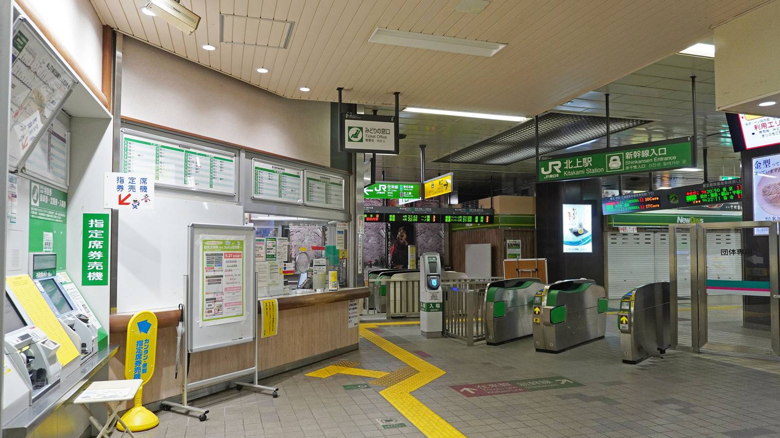Ticket gates, signs and a ticket office inside JR East's Kitakami Station in Iwate
