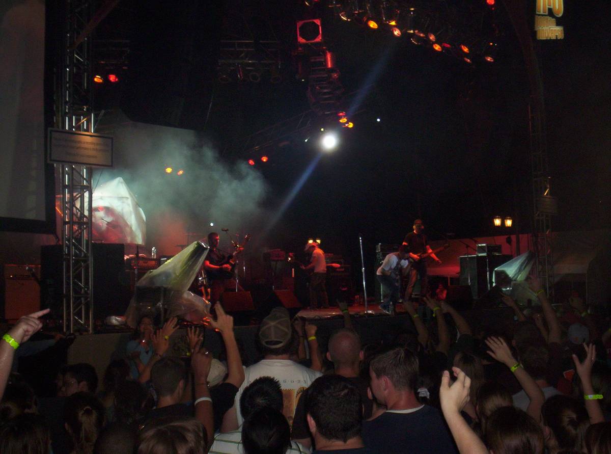 Kutless performing on a stage with a large lit screen behind