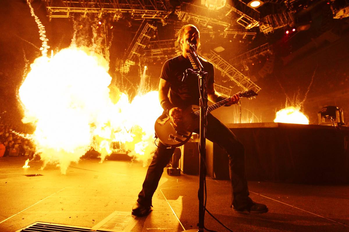 Metallica singer James Hetfield singing and playing guitar on stage