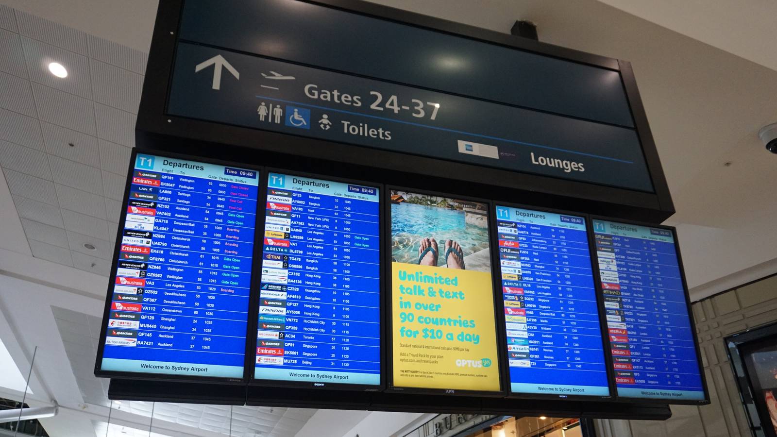 Departure screens and a sign pointing to gates 24 to 37 in Sydney Airport's international terminal