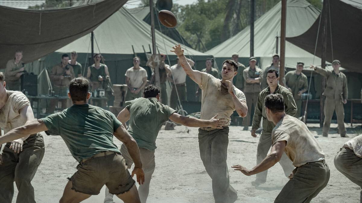 Marines in fatigues play a dusty game of football in a tent camp in a still from The Mosquito Bowl