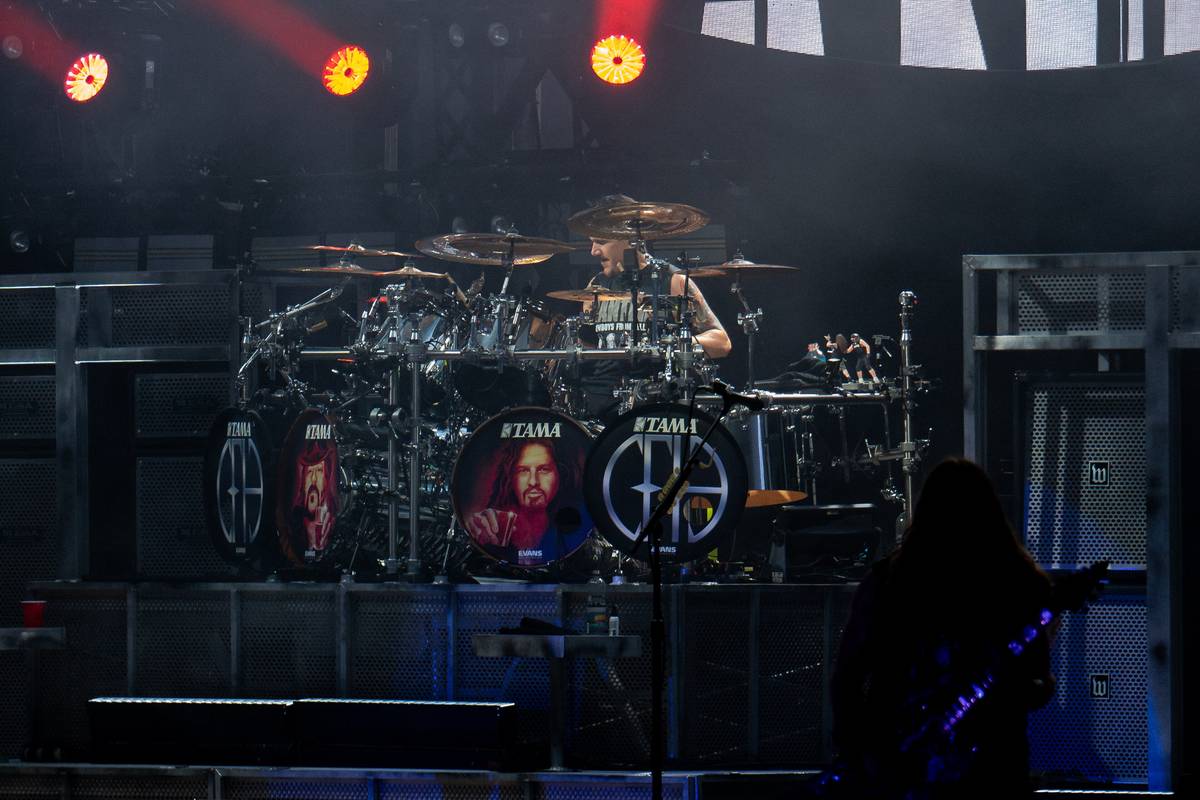 Charlie Benante behind a large drum kit on stage with Pantera