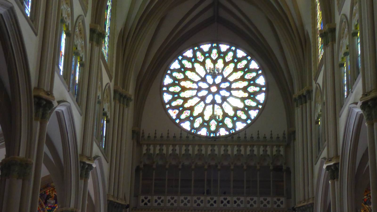 Quiet interior of Guayaquil's Metropolitan Cathedral, with Gothic arches and a stained glass rose window