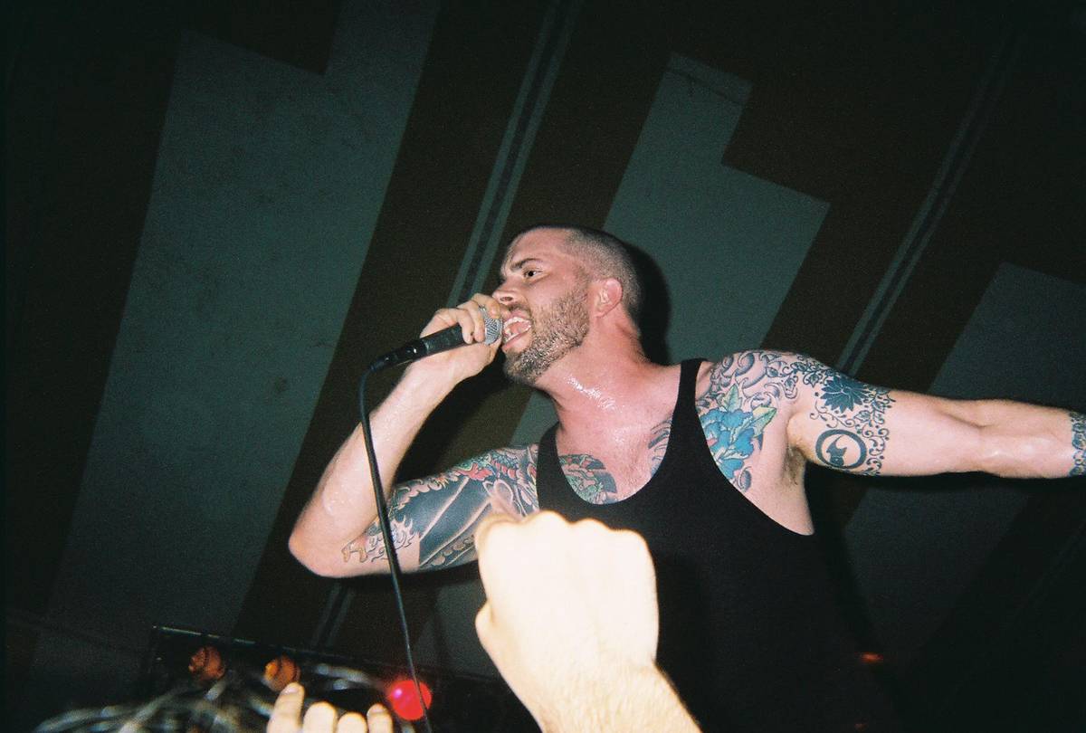 Project 86 singer Andrew Schwab singing with one arm stretched out
