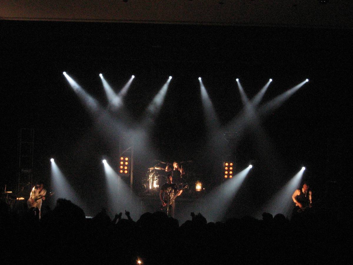 Skillet performing on a stage with white spotlights