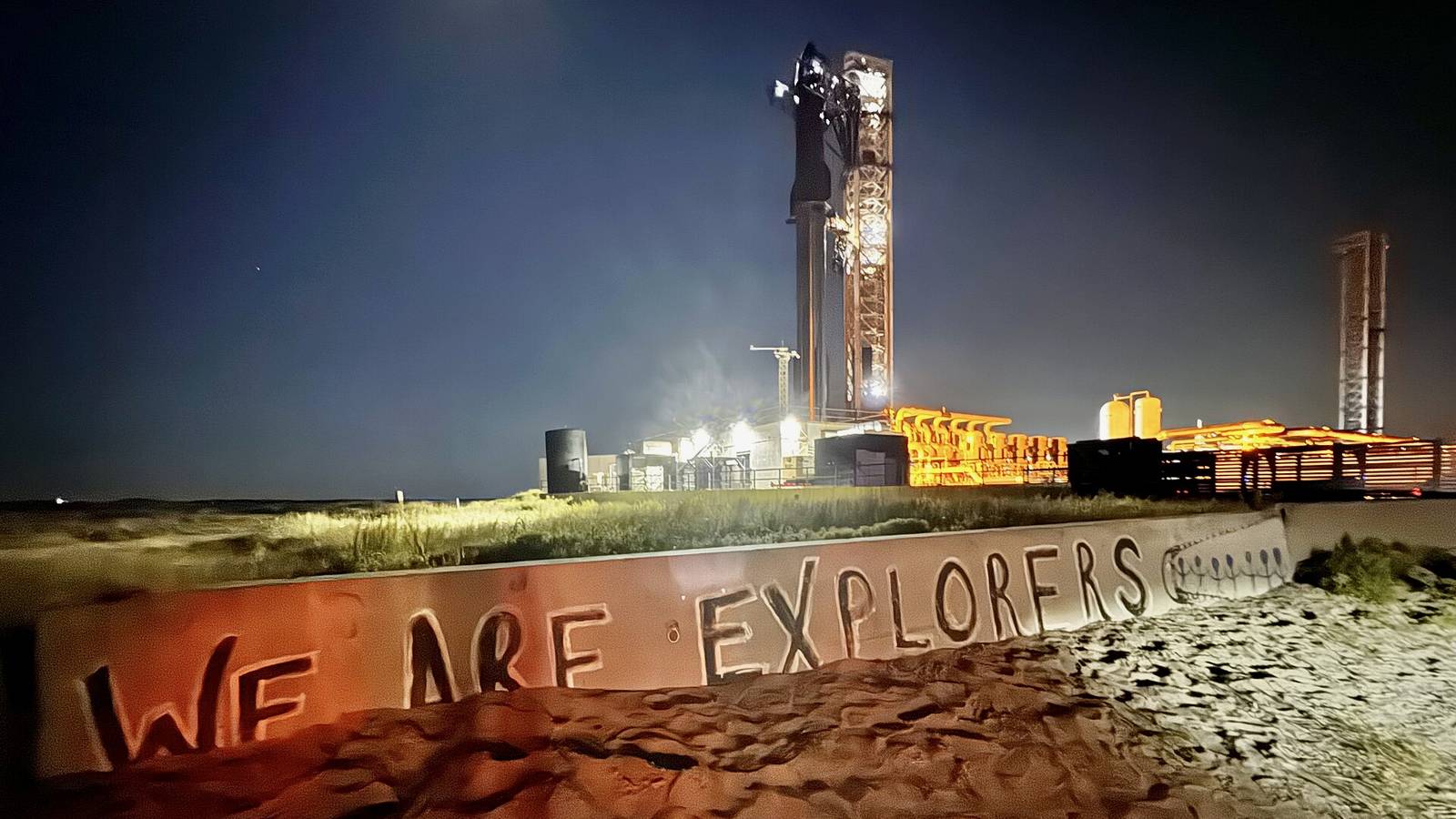 SpaceX's fully stacked Starship lit up on the launch tower at Starbase, Texas