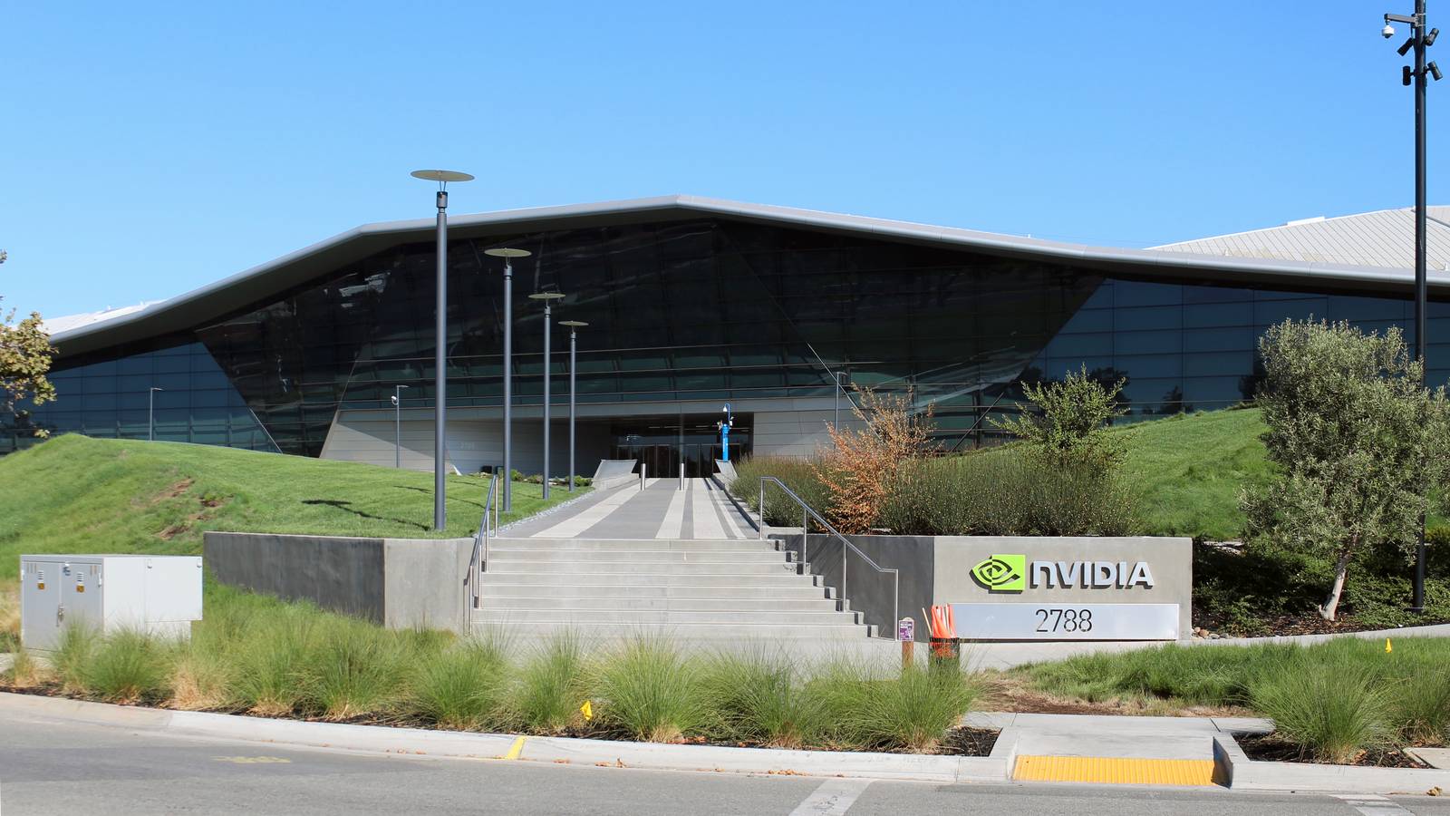 Nvidia's glass headquarters building in Santa Clara, California, with the company sign by the entrance steps