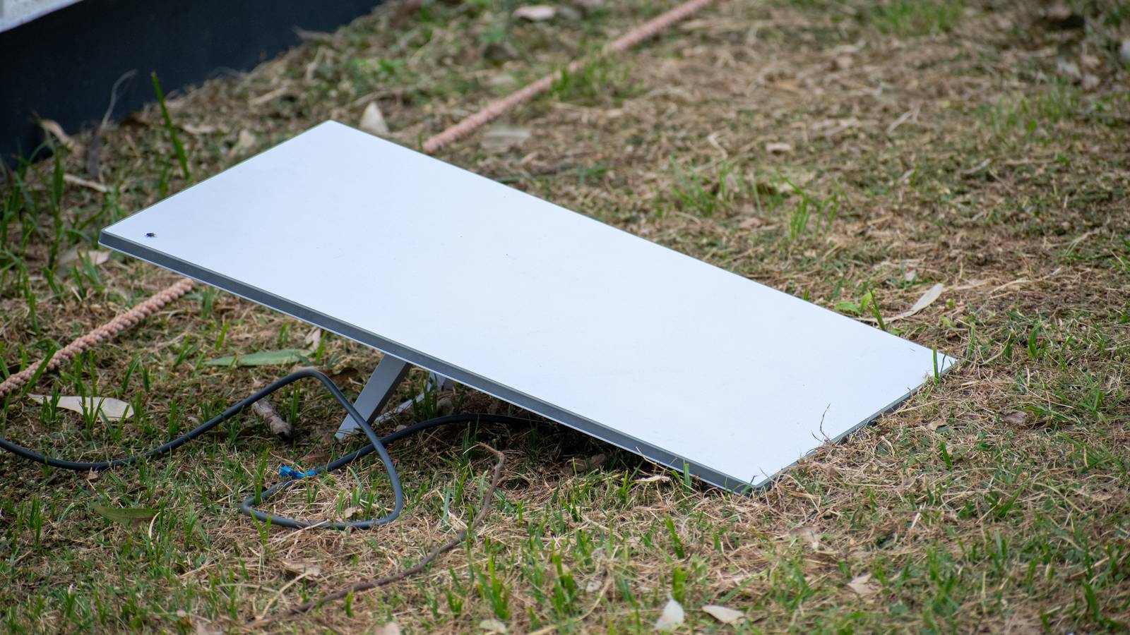 A white Starlink satellite dish standing on a patch of grass