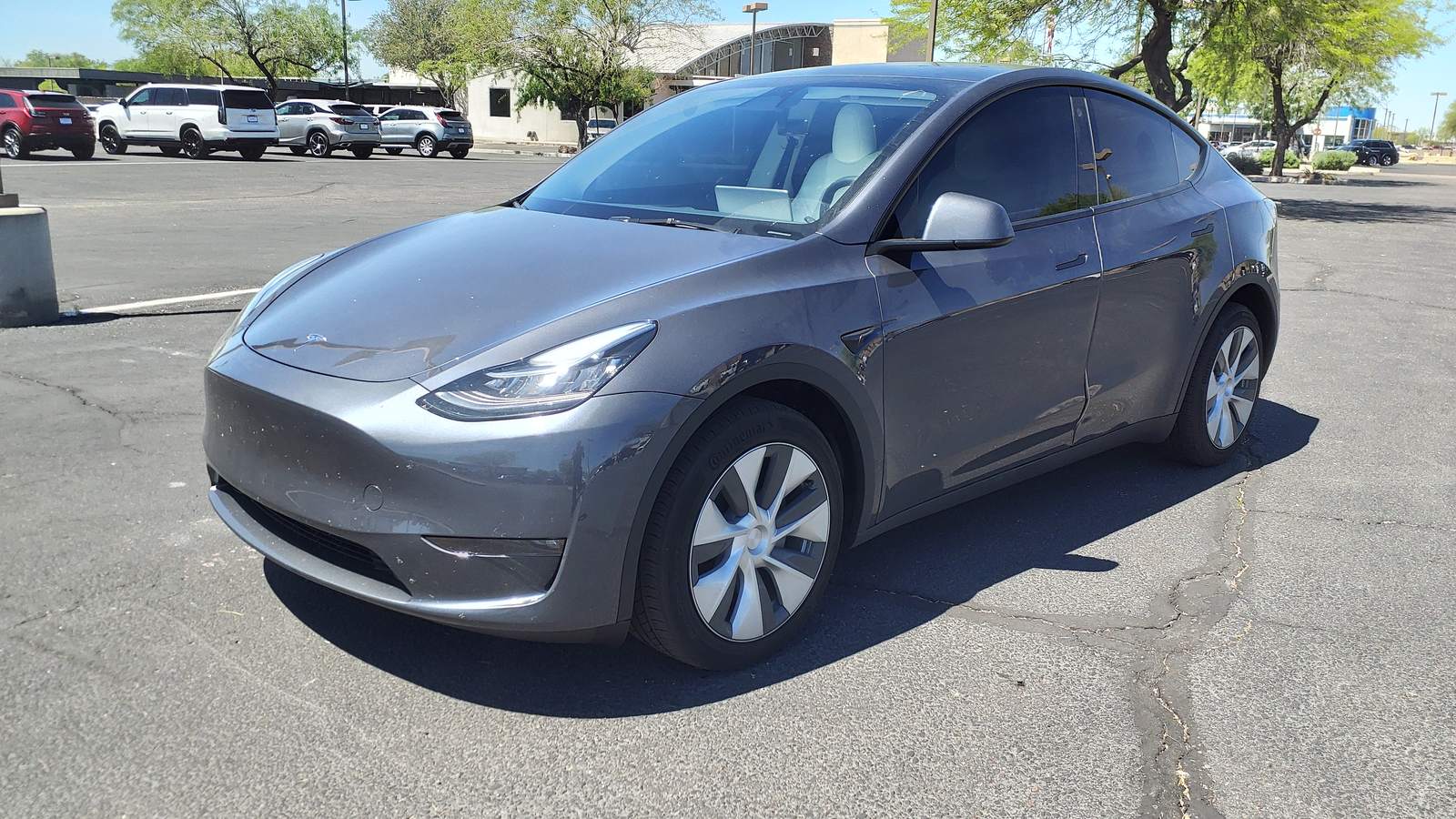 A grey Tesla Model Y parked in a car park