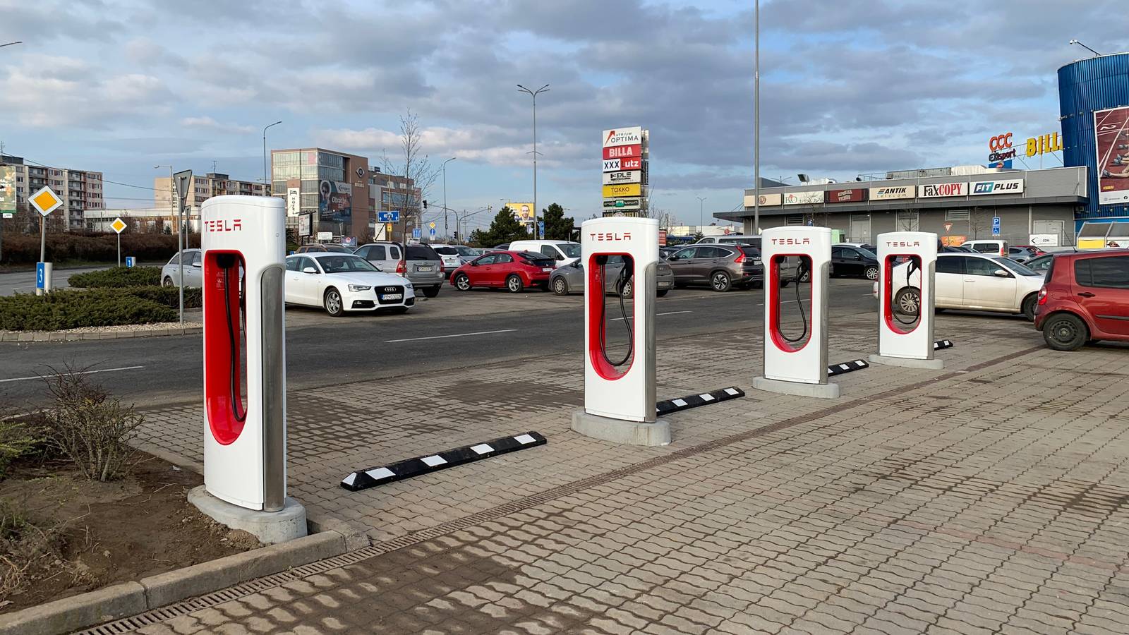 A row of red and white Tesla Supercharger stalls in a car park at the Atrium Optima centre in Košice, Slovakia