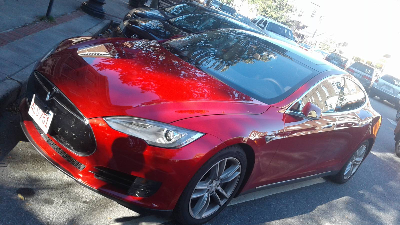 A red Tesla Model S of the original design parked on Main Street in Hanover, New Hampshire