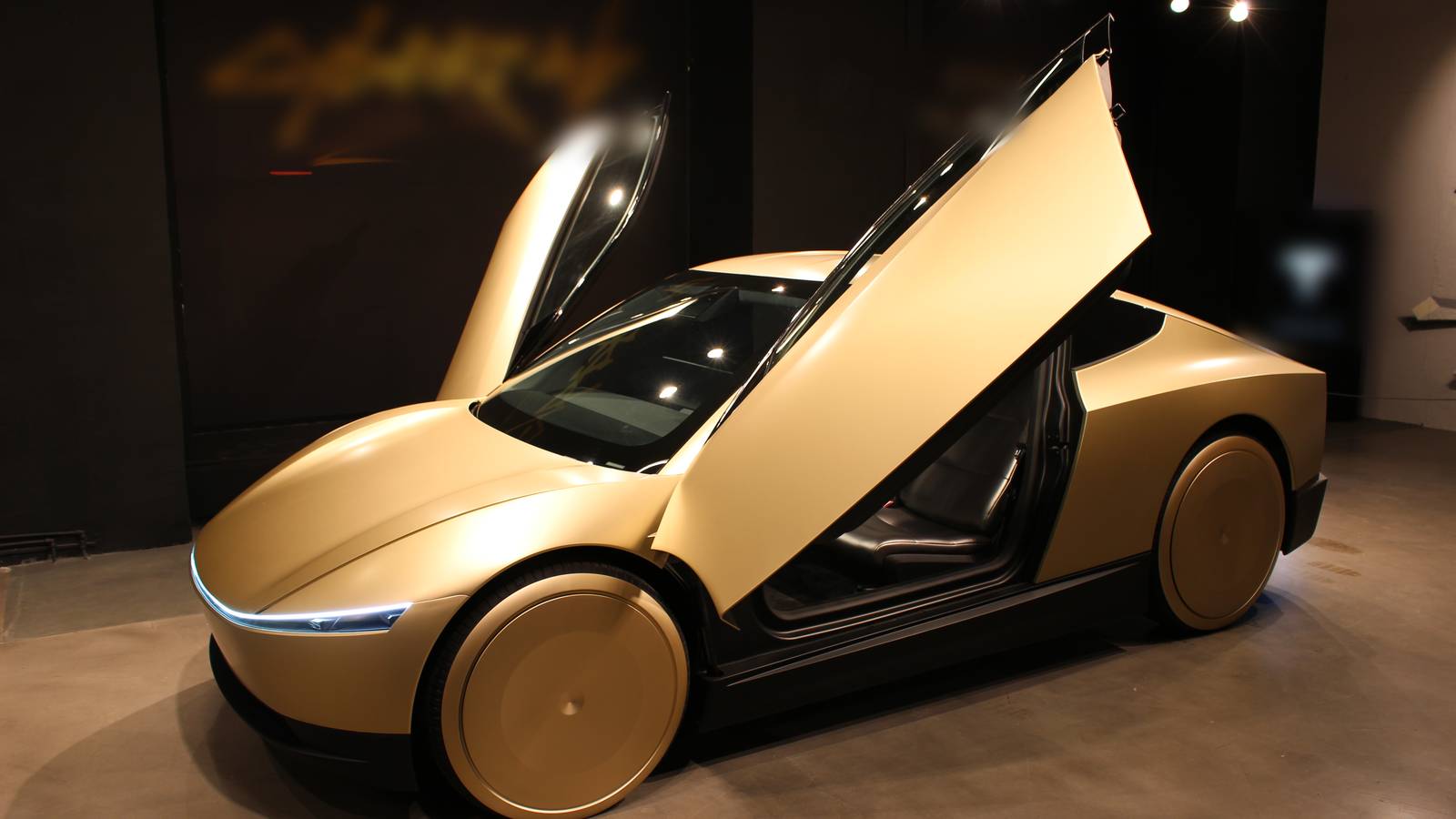 A gold Tesla Cybercab with both doors raised on display in Stockholm, December 2024
