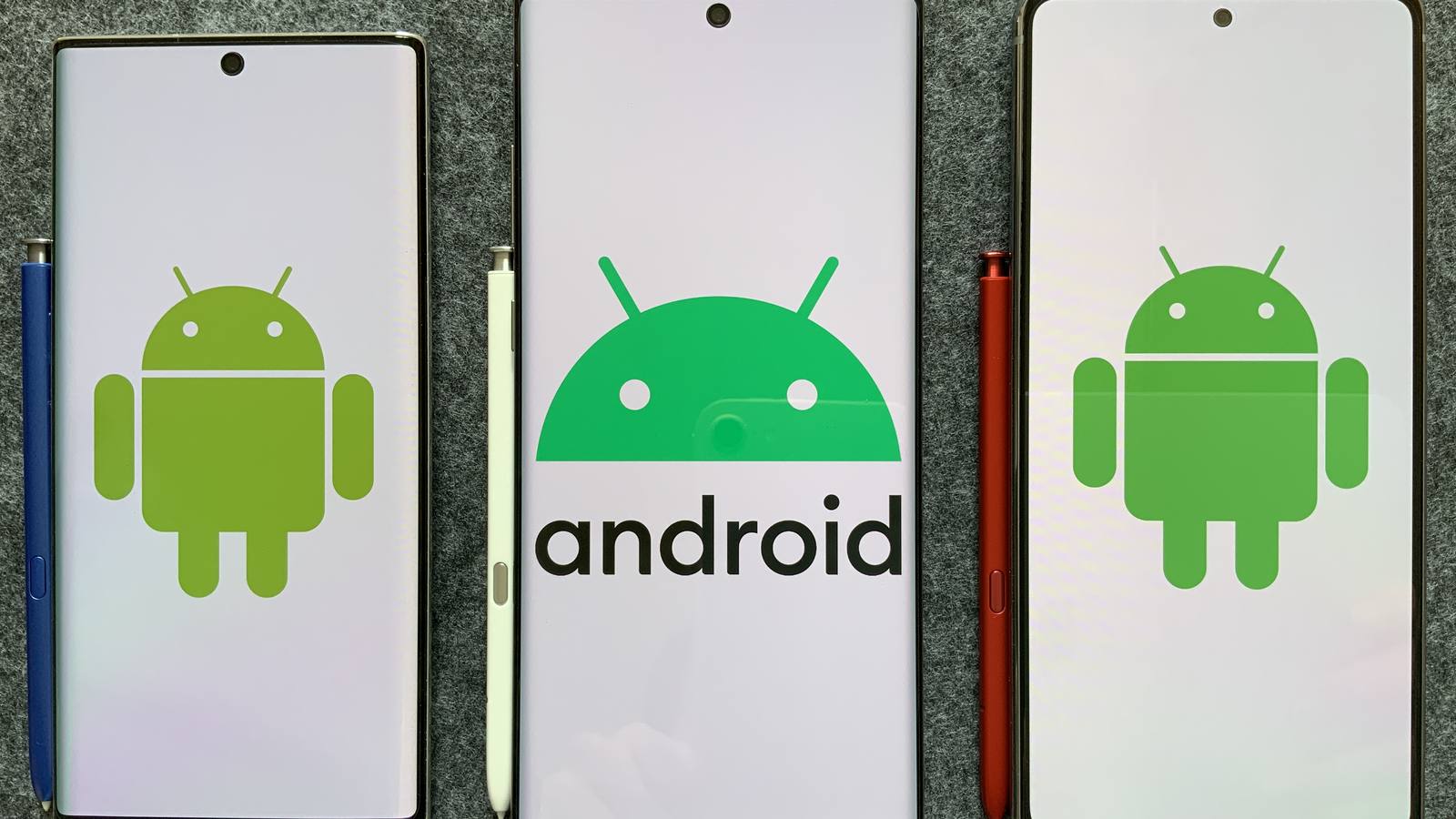 Three Samsung Galaxy Note phones side by side on grey felt, their screens showing the green Android robot logo