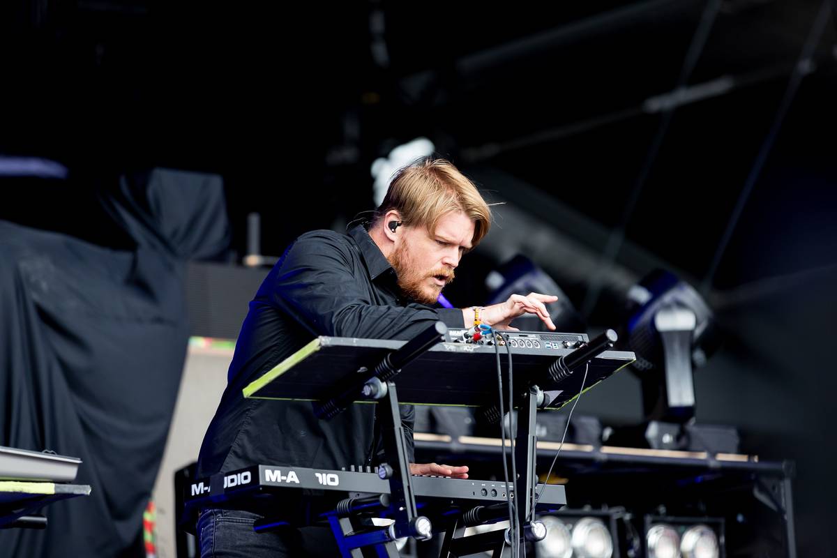 Underoath keyboardist playing behind his rig on a festival stage