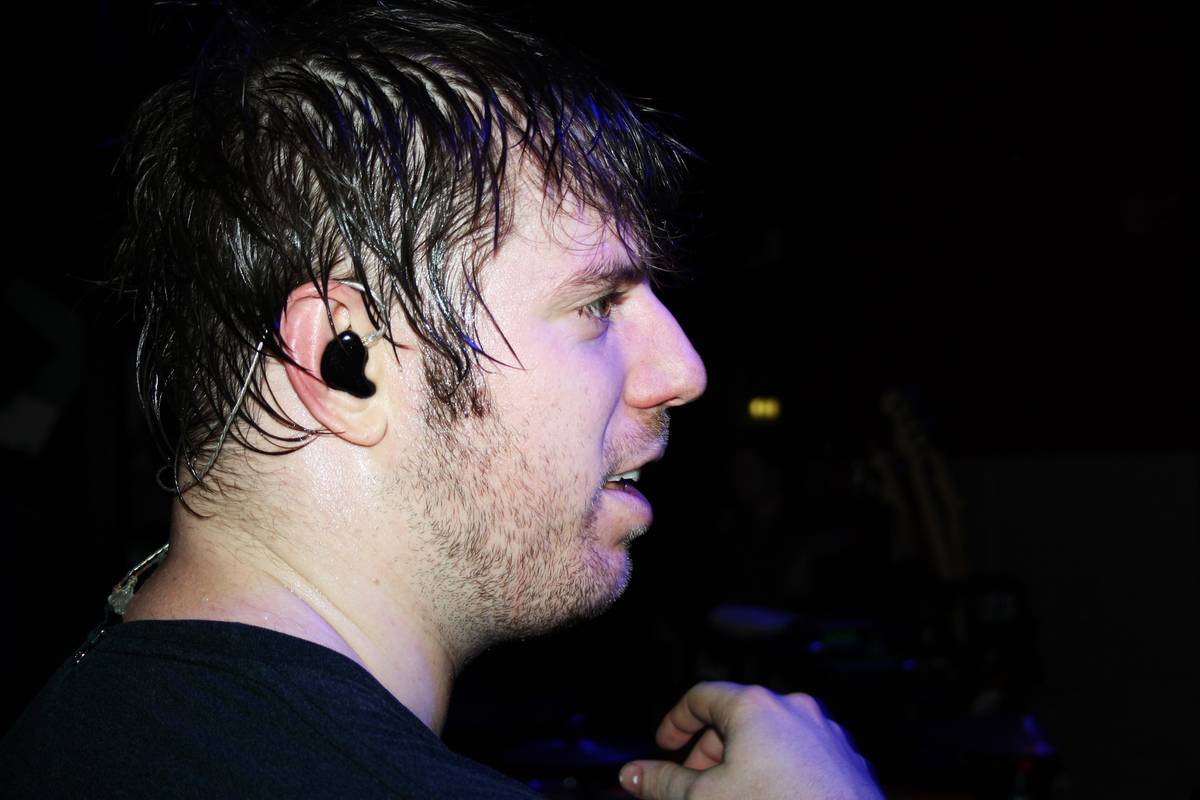 A member of Underoath on stage in profile