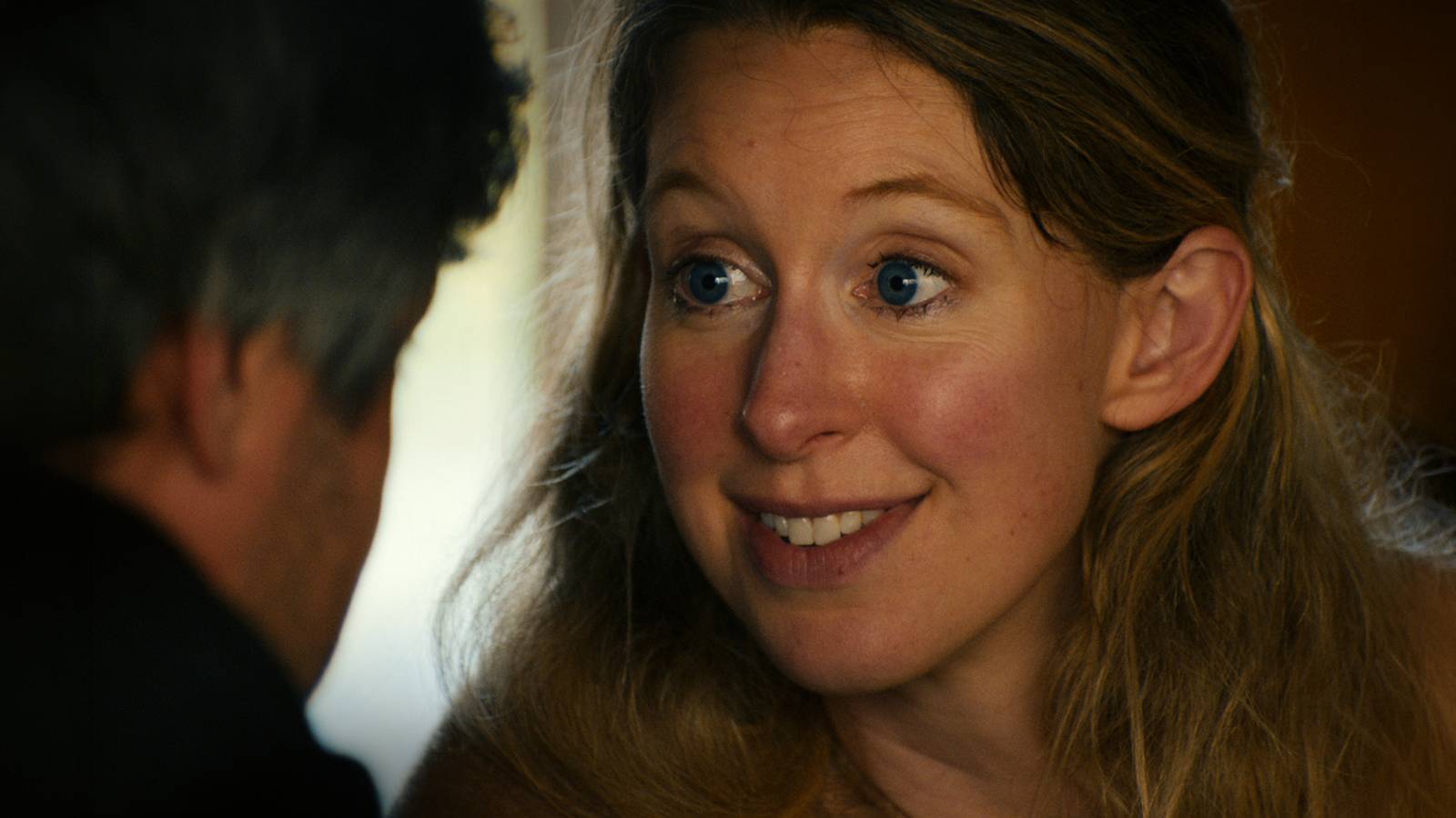 Elizabeth Holmes smiles in a still from the A24 documentary You Can See Everything