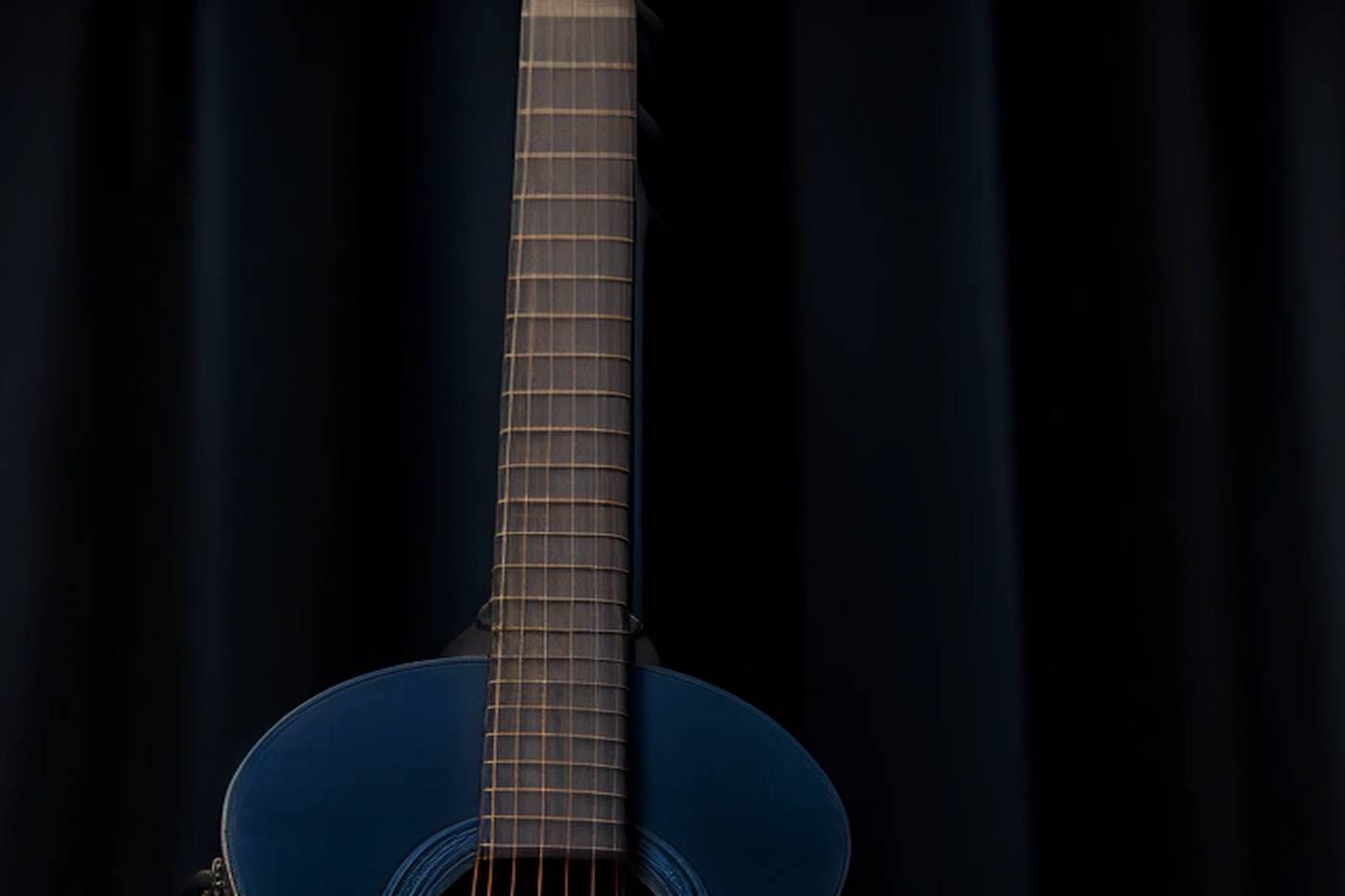Classical guitar neck under cold blue light.