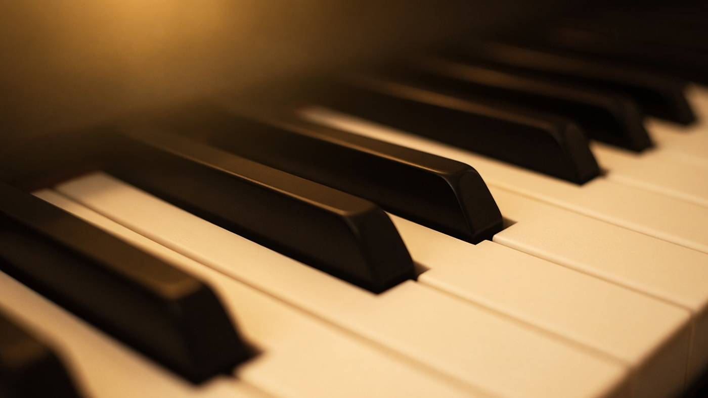 Piano keys in warm amber light.