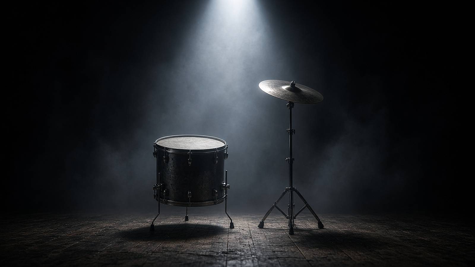A lone floor tom and crash cymbal under a single spotlight on a hazy club stage.