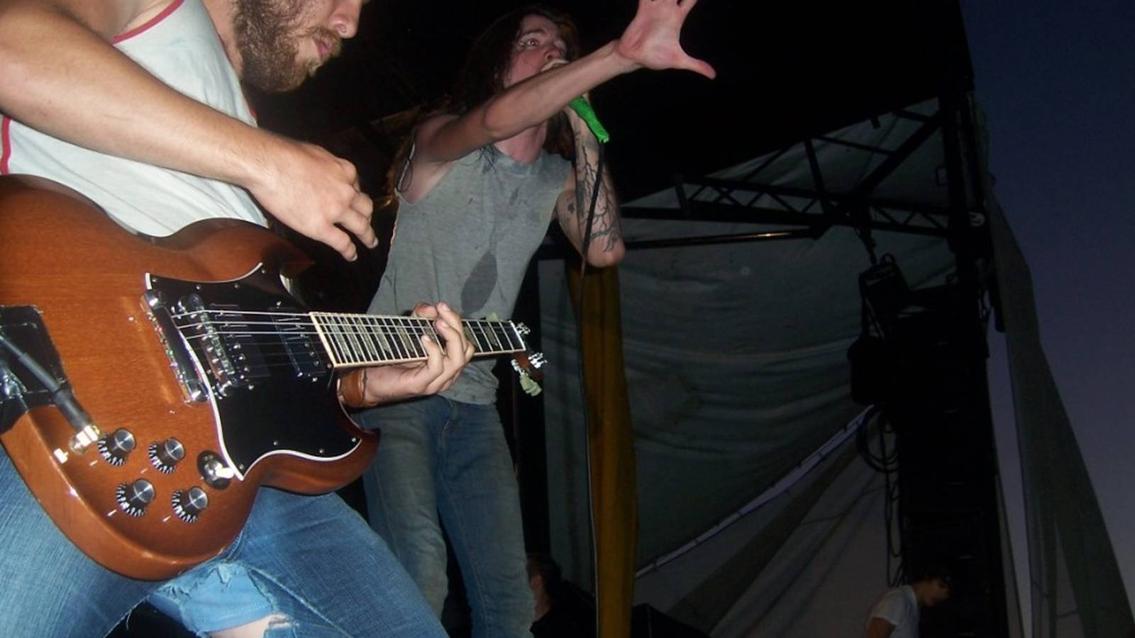Underoath playing outdoors on the Vans Warped Tour stage in daylight